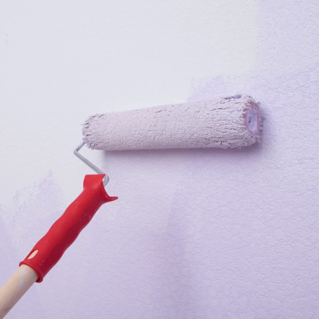 Paint roller applying fresh paint to an interior wall