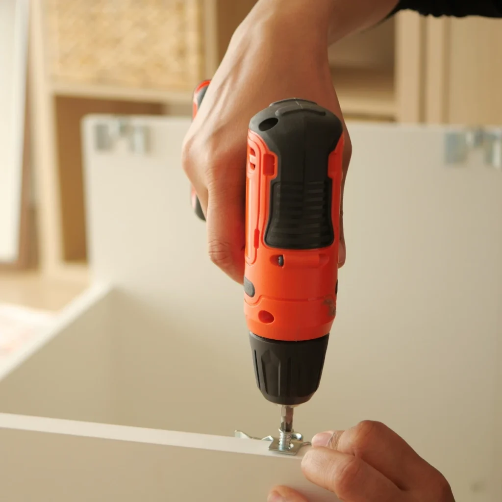 Furniture components being assembled with a cordless drill