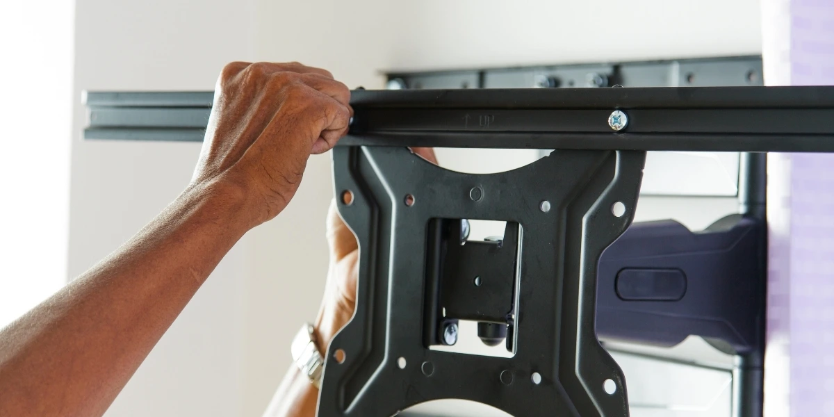 Handyman installing a TV wall-mount bracket