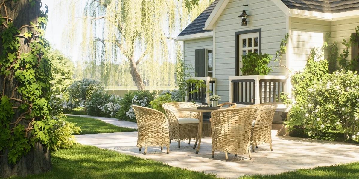 Landscaped backyard patio with outdoor dining furniture beside a home